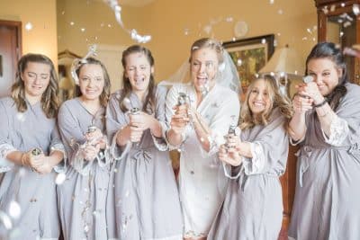 bride and her bridesmaids, celebrating before the wedding ceremony, wearing bathrobes, popping confetti, Orlando, FL