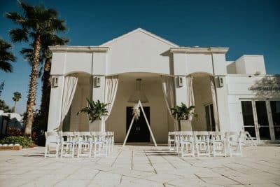 wedding ceremony set up, outdoors, white chairs in rows, center aisle, triangle at the altar area, large white building, Renaissance Orlando Resort and Spa, Orlando, FL