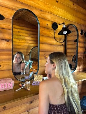 woman touching up her make up in the mirror in the bridal suite, Cabin 52, Orlando, FL