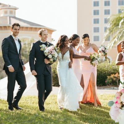 bride, groom and wedding party attendants walking in the grass towards their wedding reception, Orlando, FL