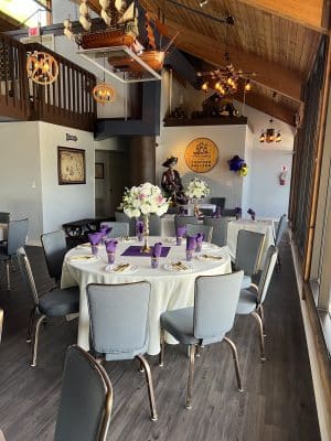 corner table in the dining area, grey chairs, purple napkins, white tablecloth, white floral centerpiece, Orlando, FL