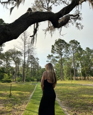 woman standing under a large tree, cabin 52, Orlando, FL