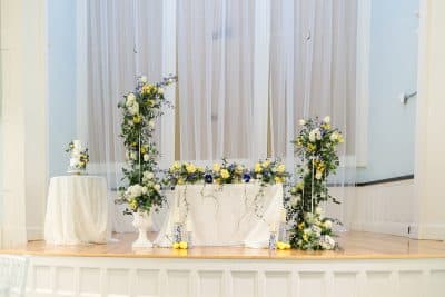 altar set up, white and yellow flowers, white tablecloths, raised stage area, Orlando, FL