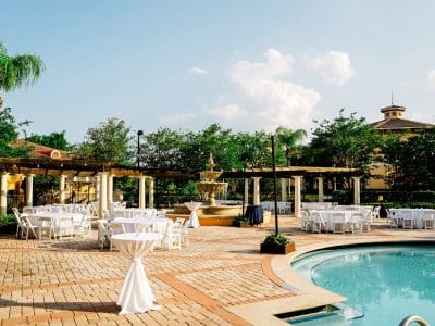 pool patio area with cabanas and tables on the deck, cocktail reception, clear blue skies, Orlando, FL
