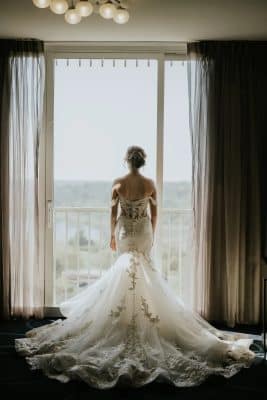 bride in her wedding gown, standing in front of a window, the train of her dress spread out for display, Renaissance Orlando Resort and Spa, Orlando, FL