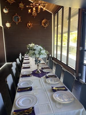 close up of a table, white tablecloth, grey chairs, white plates, white floral centerpiece, Orlando, FL