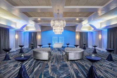 ballroom set for cocktail hour with small tables around and silver sofas in the center of the room, Orlando, FL