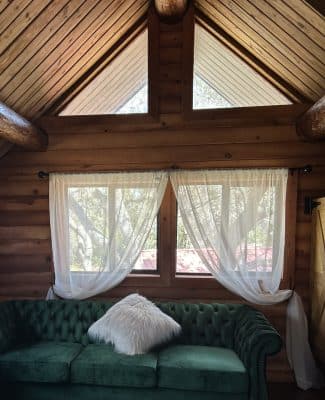 cabin inside view, window, sofa with white pillow, cabin 52 event venue, Orlando, FL