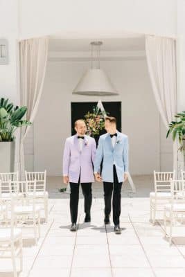 two grooms in their purple and blue suit jackets with black dress pants, white curtains, white chairs in rows, set for a ceremony, Renaissance Orlando Resort and Spa, Orlando, FL
