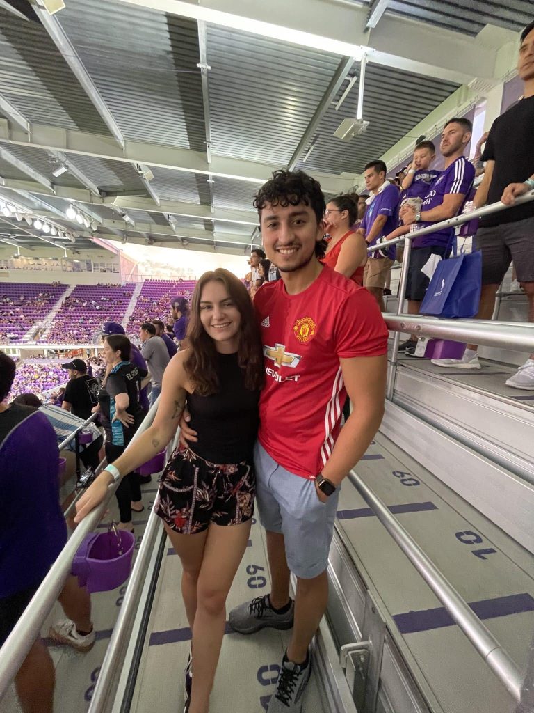 couple smiling in the bleachers for a soccer game