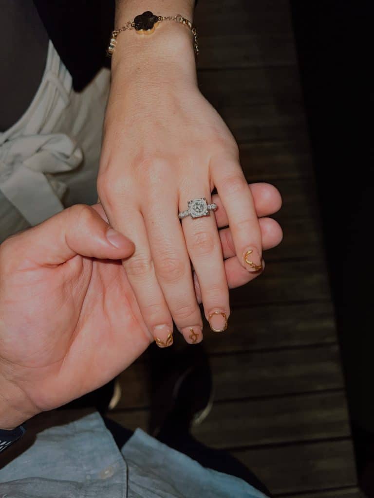 engaged couple showing their engagement ring while holding hands from their Italy marriage proposal