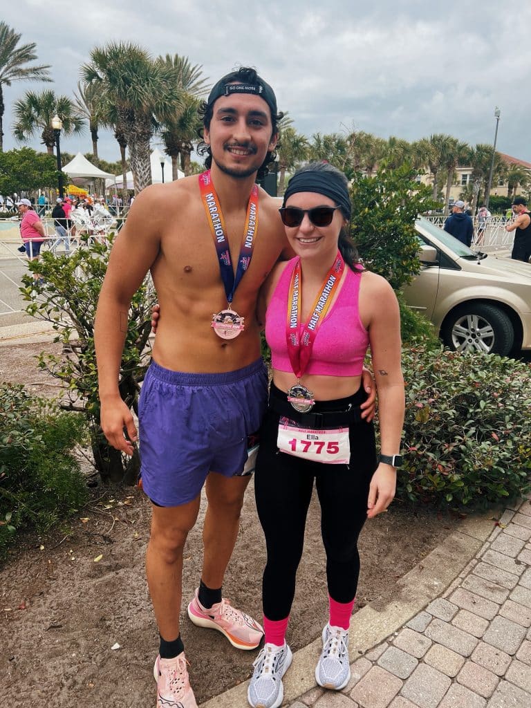 couple outdoors with running gear and metals
