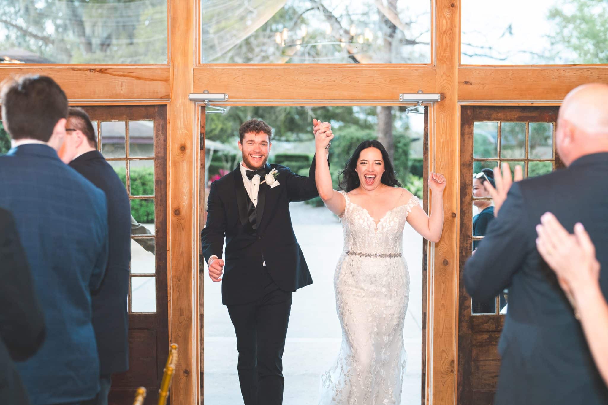 bride and groom introduced at reception with wooded farmhouse entrance door background