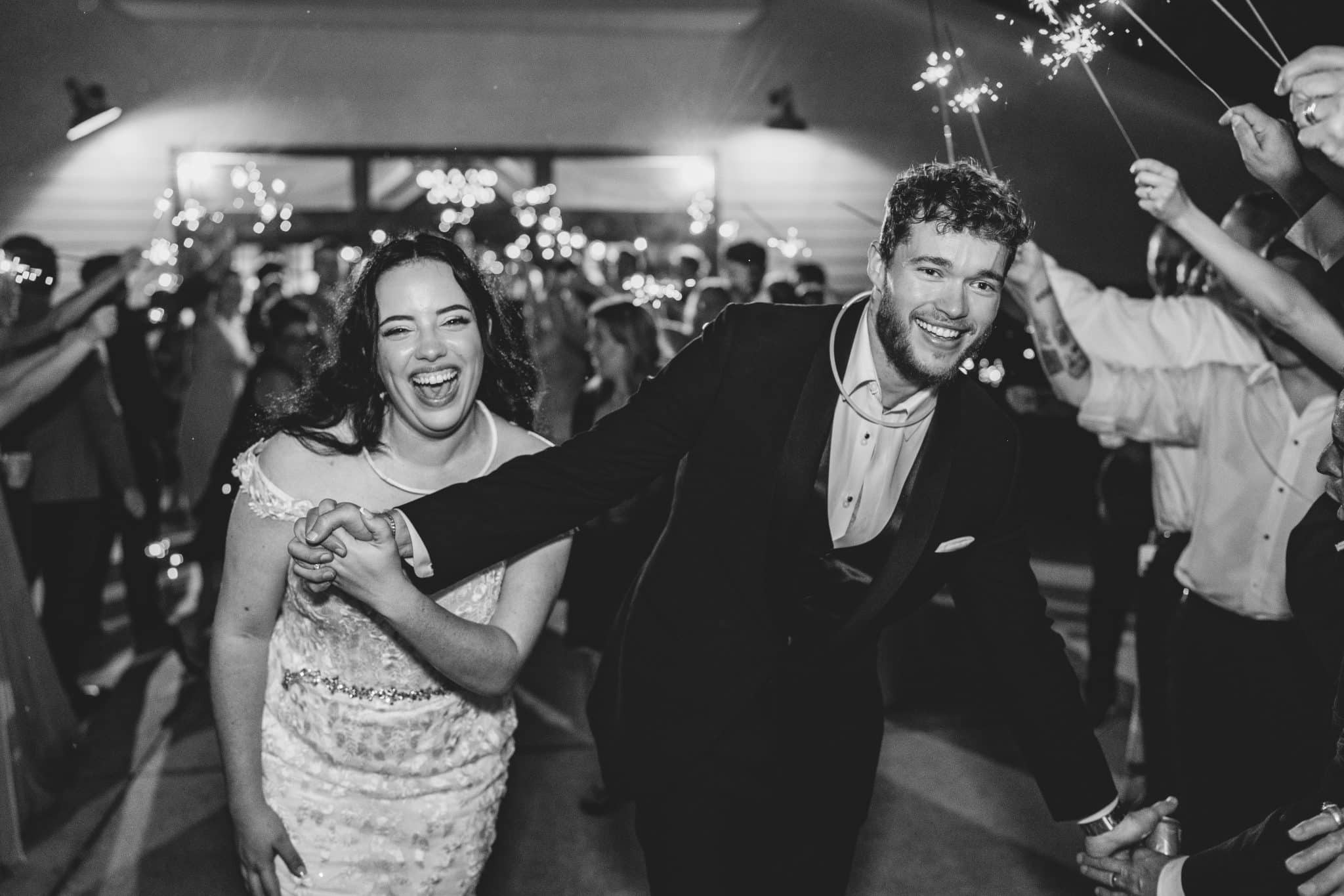 black and white image of a newly married couple celebrating their grand sparkler exit