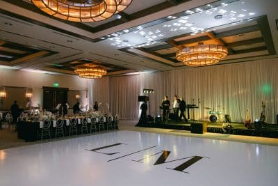 live band set up on stage, large dance floor with L/M on the center, tables surrounding, The Alfond Inn, Orlando, FL