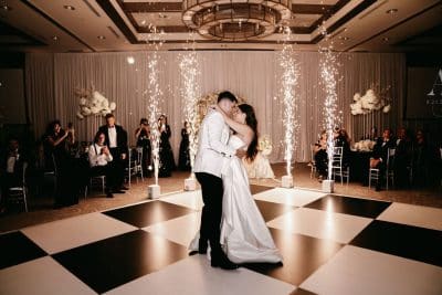 black and white photo of a bride and groom dancing on the checkerboard dance floor, sparklers going off band playing behind the couple, The Alfond Inn, Orlando, FL