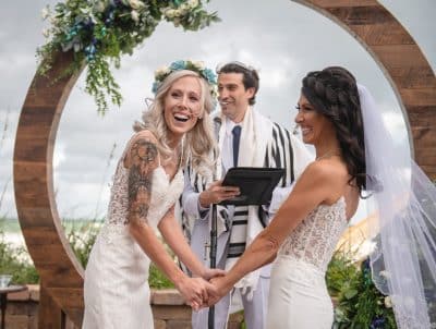 two brides laughing with their officiant during their ceremony, Orlando, FL
