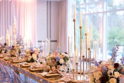 tablescape, long table with floral centerpieces down the center, tall candles, large windows,