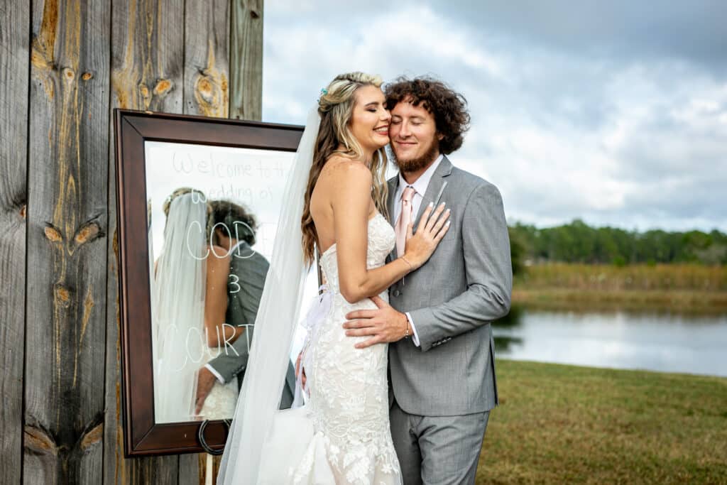 bride and groom embracing each other, outdoors, mirror on an easel near the building, Orlando, FL