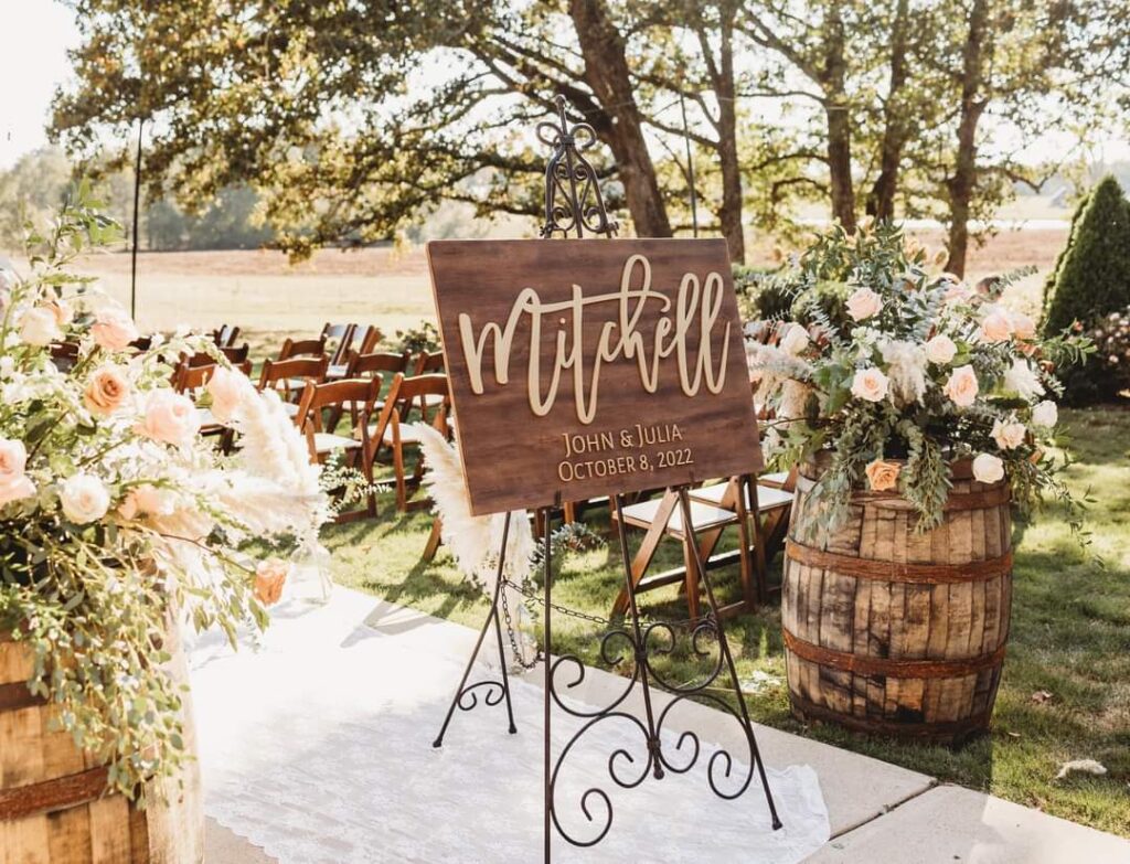 wooden welcome sign, outdoor ceremony, cursive writing, large barrels with white flowers, Orlando, FL