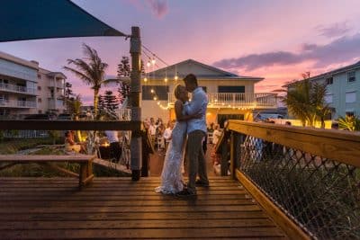 couple dancing on a wooden patio, venue in the background, sunset, Orlando, FL