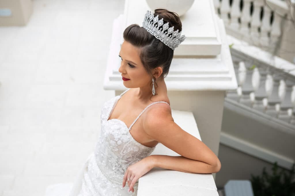 bride leaning on a railing by the grand staircase, wearing a tiara, Dream Day Digital, Orlando, FL