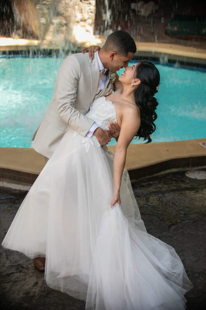 bride being dipped by her groom, near an outdoor pool, Orlando, FL