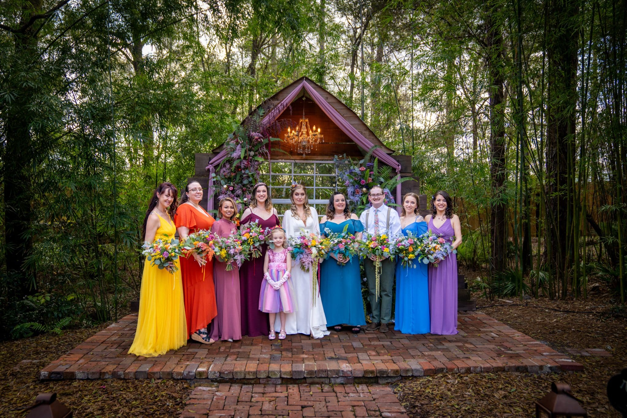 bridal party with non traditional wedding colors on their dresses like bright yellow, orange and bright blue. 