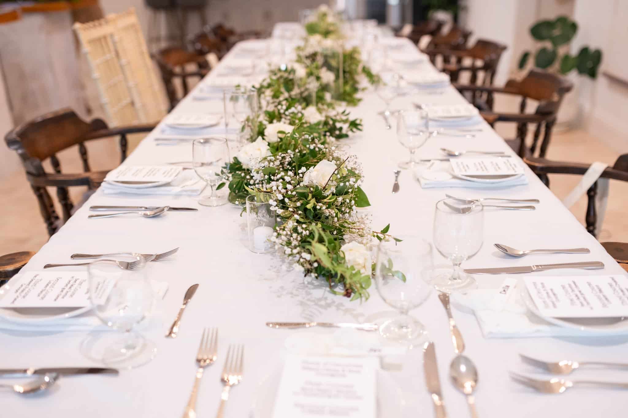 reception table shown for intimate wedding with 17 people total. Greenery on the table 