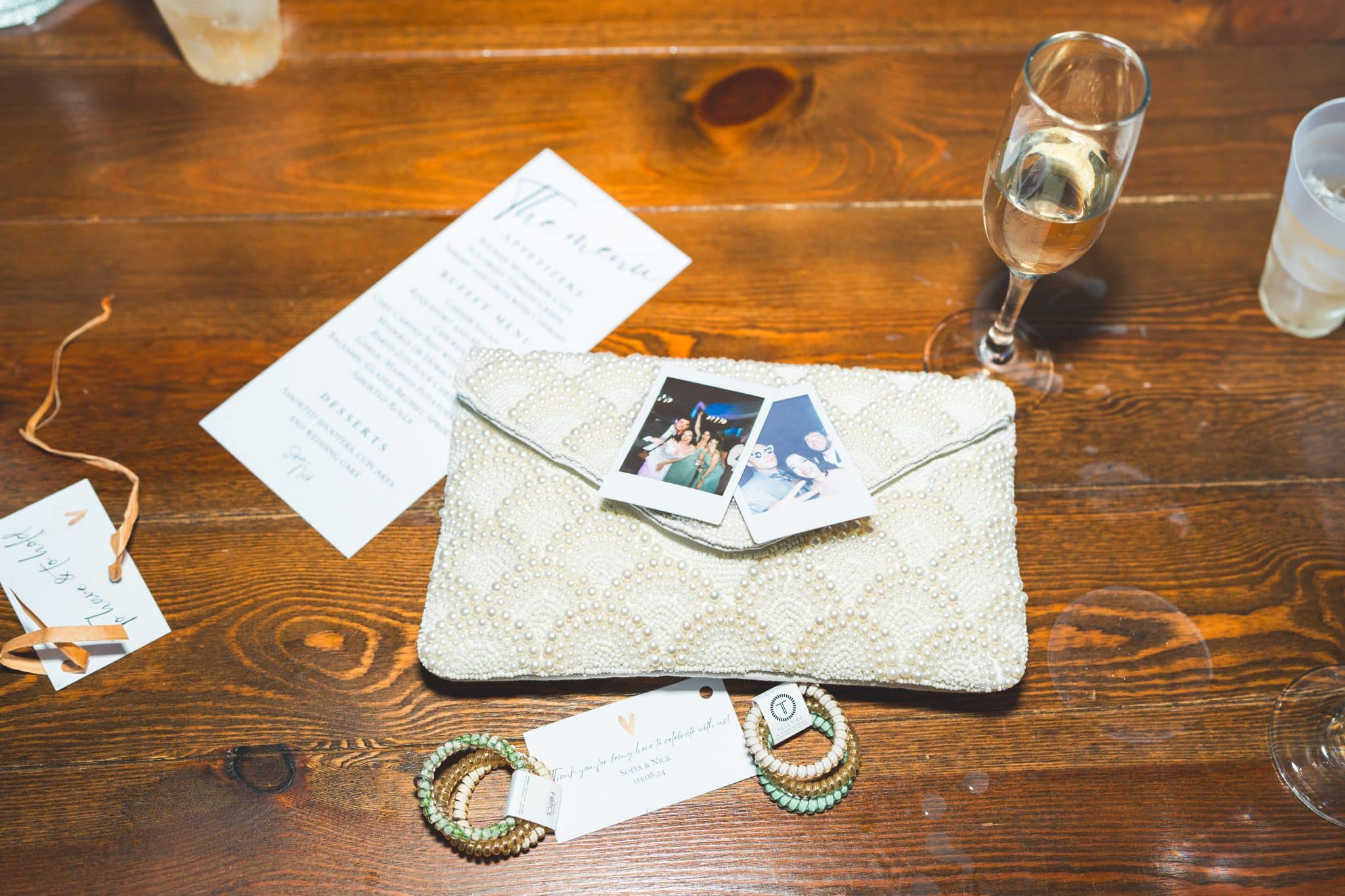 Messy detailed shot with wallet, champagne flute and printed images of the couple