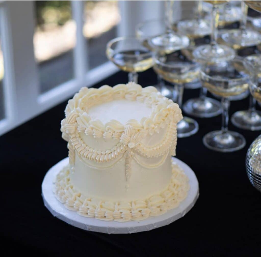 one tiered white cake, buttercream frosting, black tablecloth, Iced by Taylor, Orlando, FL