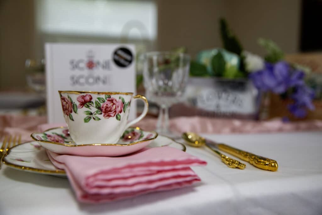 pink floral tea cup and tea towel, gold lined plate, scones, white table cloth, Houses of Windsor, Orlando, FL