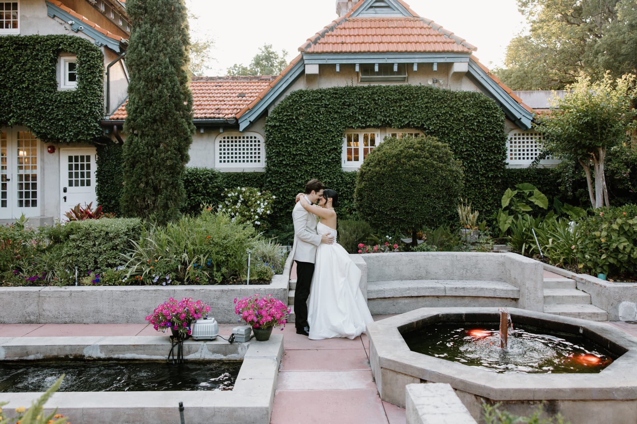 Couple kissing in front of Sydonie Mansion with a gorgeous greenery background