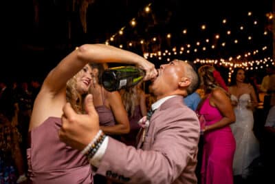 wedding guests dancing, one guest pouring champagne into another guests mouth, Sonacity Photography, Orlando, FL