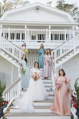 bridesmaids standing on the gran staircase outside, leading up to the main building at Uliana Estate, Orlando, FL