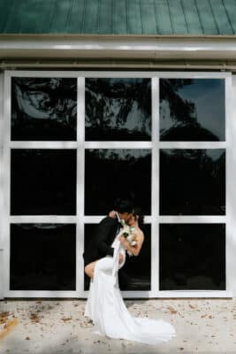 bride and groom kissing in front of a large window with nine panes, Orlando, FL