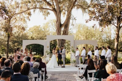 wedding ceremony, outdoors, large trees, wedding guests in row of chairs, Orlando, FL
