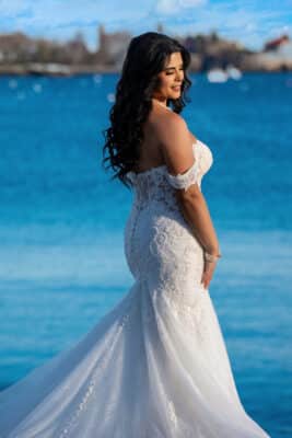 bride standing in her wedding gown at the water's edge, clear blue water,r land in the distance, Orlando, FL