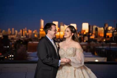 bride and groom holding hands and looking at each other, nighttime, cityscape behind them, Sonacity Photography, Orlando, FL