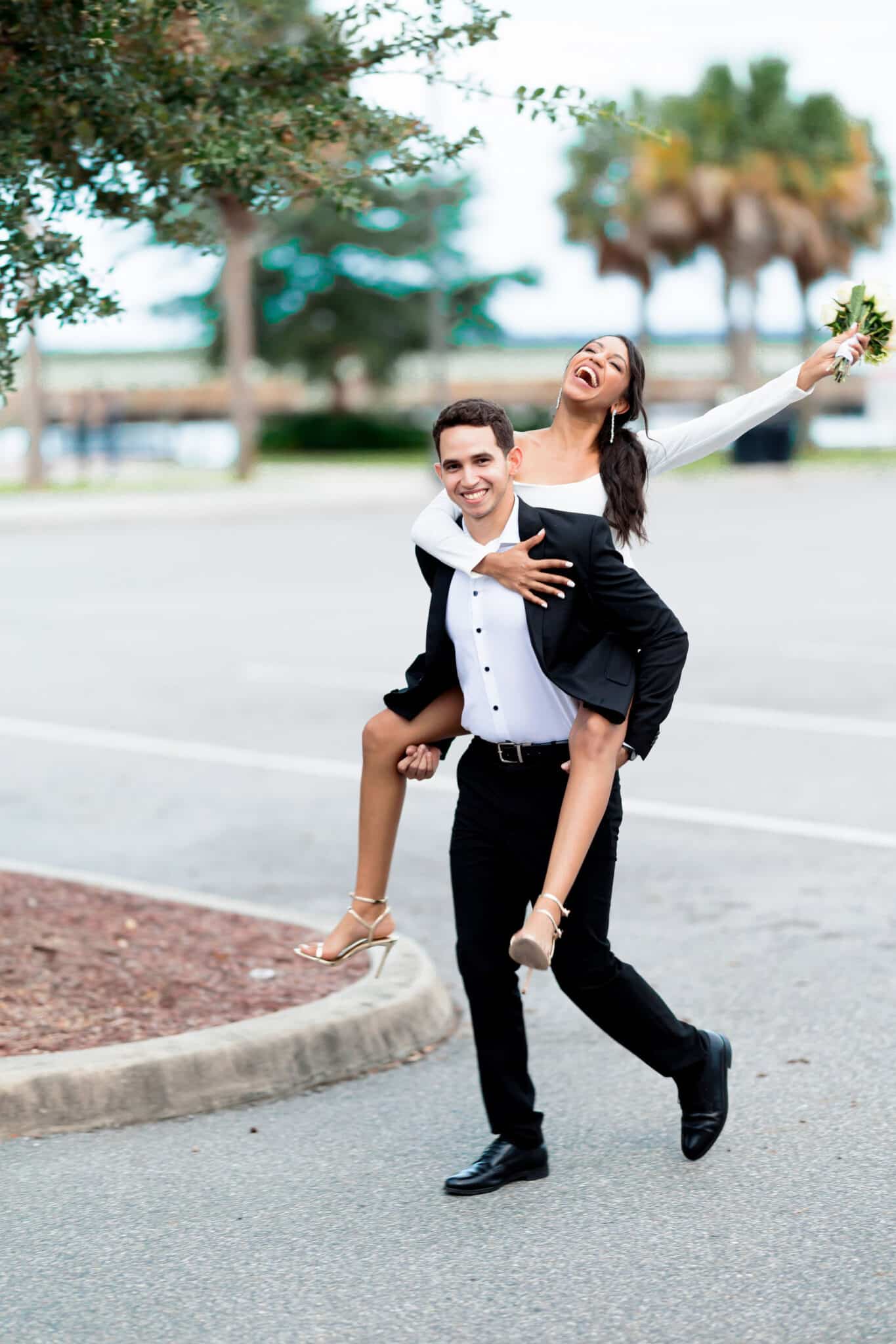 groom carrying bride with florals on hand