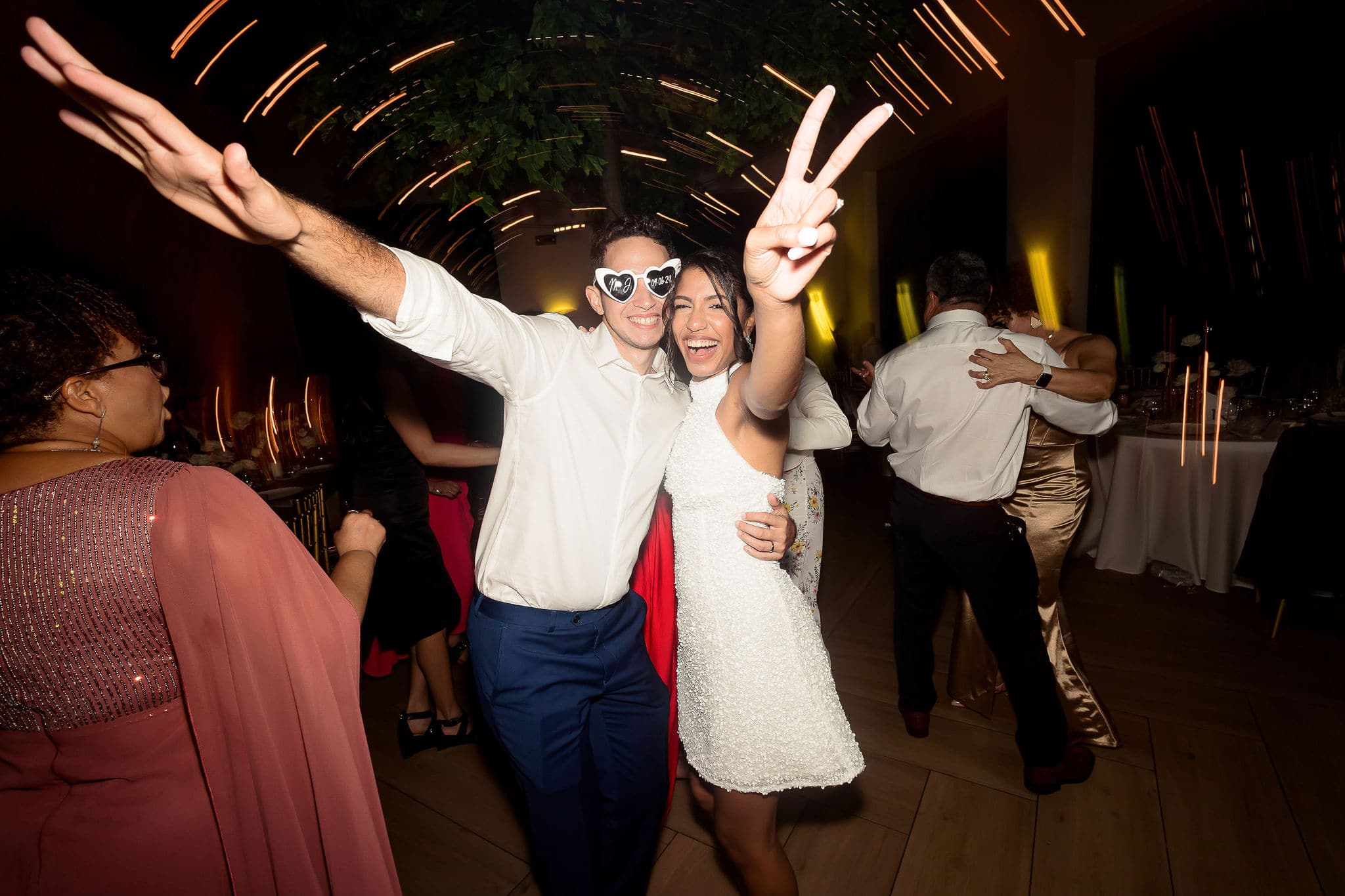 bride and groom celebrating their timeless and chic wedding with a full dark background