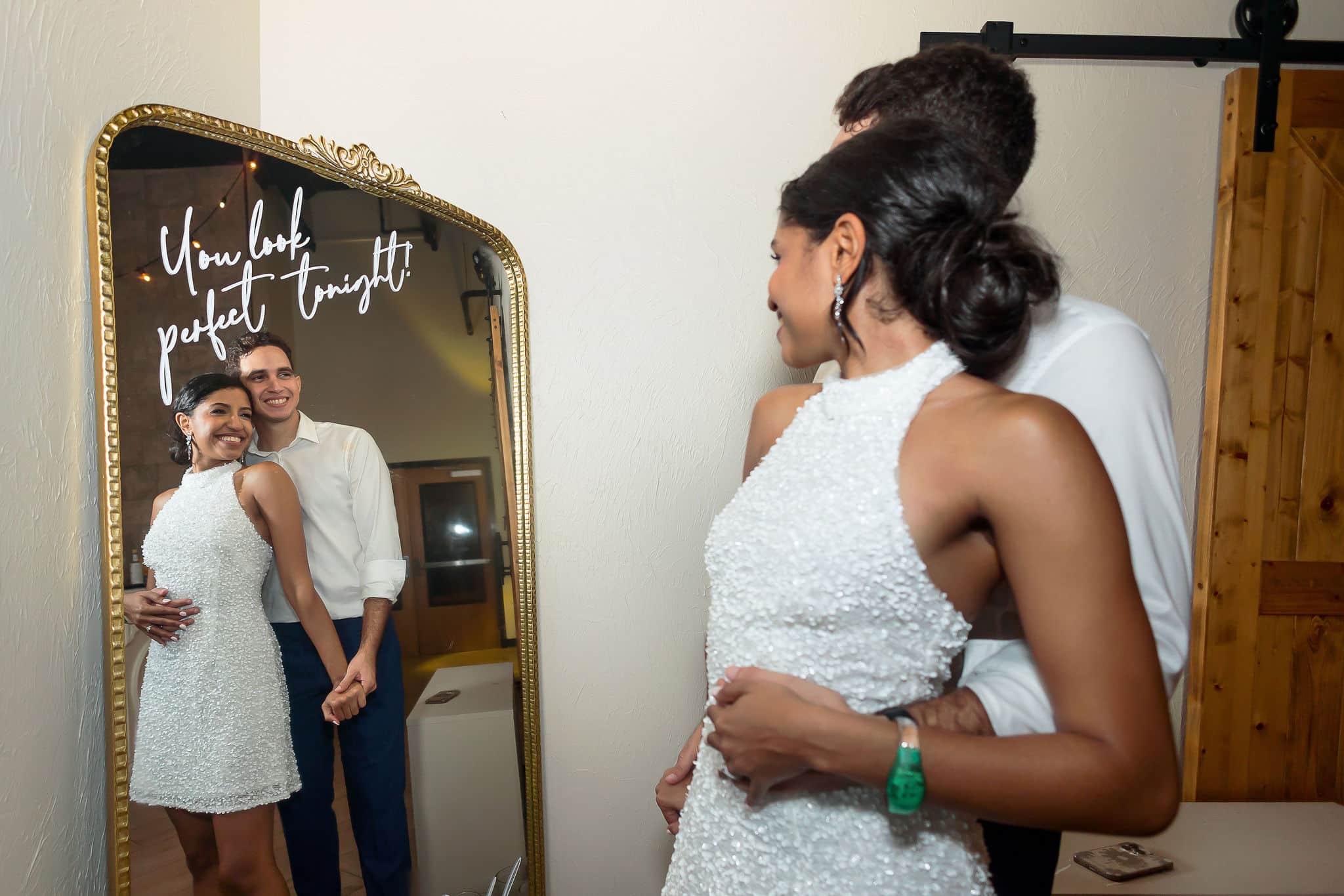 bride and groom posing in front of their wedding mirror