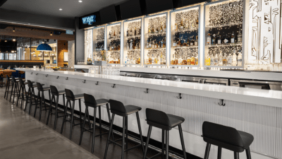 bar area, long white bar, black stools, bottles of alcohol on display behind the bar, Orlando, FL