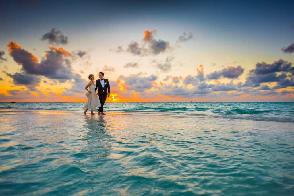 married couple walking on the beach