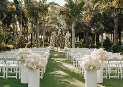 outdoor wedding ceremony set up, white chairs, white columns filled with white flowers, Lake Nona Wave Hotel, Orlando, FL