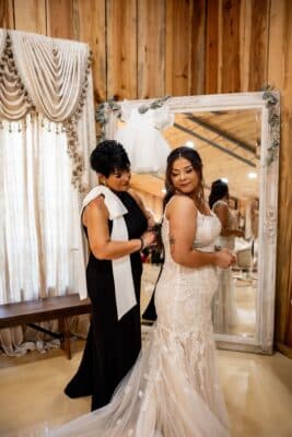 bride being assisted by her mother as she dresses for the wedding ceremony, Rustic Grace Barn, Orlando, FL