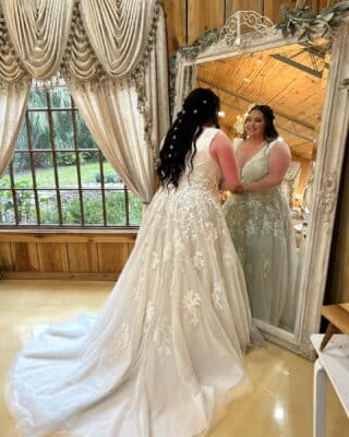 bride looking at herself in the large floor length mirror, Rustic Grace Barn, Orlando, FL