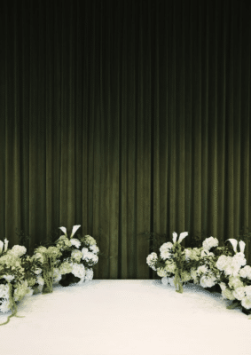 stage area with white and green florals, tall black curtain, The Great Southern Box Co., Orlando, FL