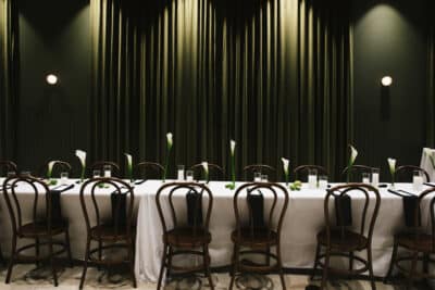 dinner reception table set, green ridged wall with green downlighting, black chairs, black napkins, The Great Southern Box Co., Orlando, FL