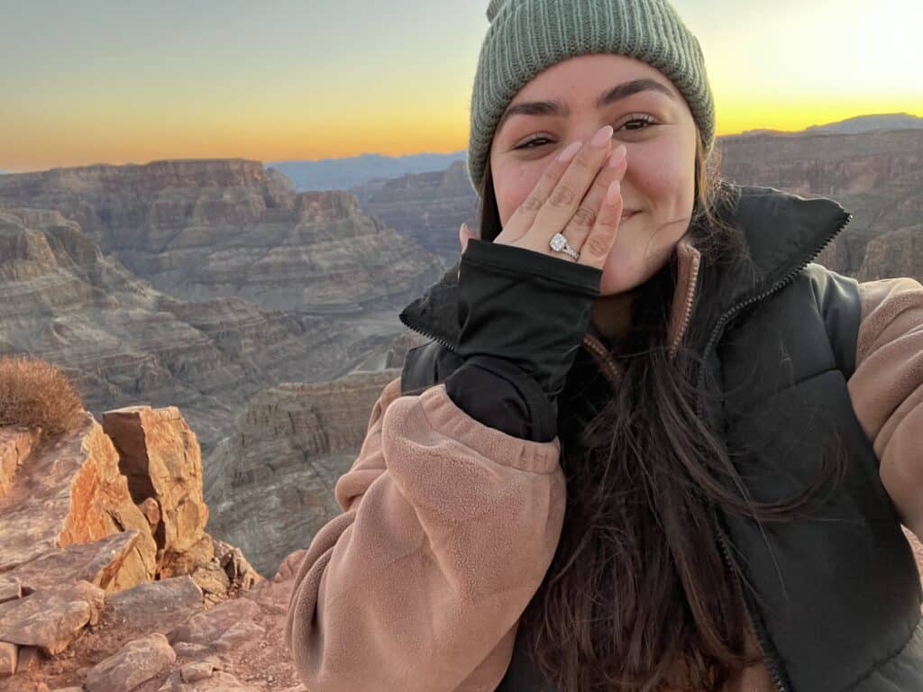 Girlfriend showing off her engagement ring covering her face with her hand after her Grand Canyon marriage proposal. 